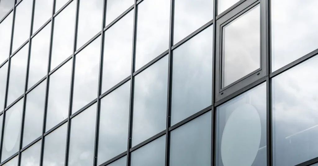 A modern glass facade reflecting a cloudy sky, showcasing contemporary architecture.